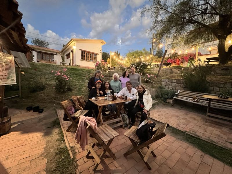 Grupo reunido en una mesa del patio al atardecer.